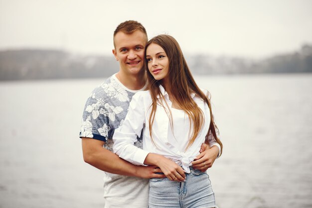 Hermosa pareja pasa tiempo en un parque nublado de otoño