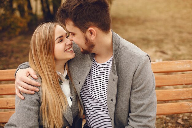 Hermosa pareja pasa tiempo en un parque de otoño