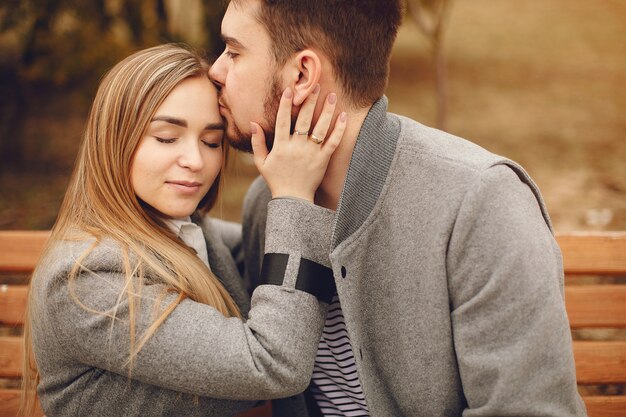 Hermosa pareja pasa tiempo en un parque de otoño