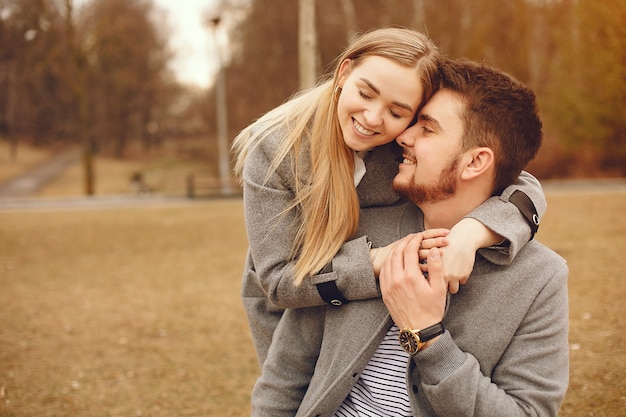 Hermosa pareja pasa tiempo en un parque de otoño