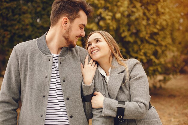 Hermosa pareja pasa tiempo en un parque de otoño