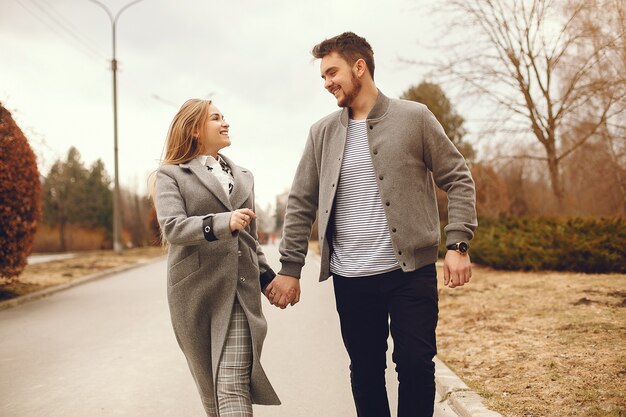 Hermosa pareja pasa tiempo en un parque de otoño