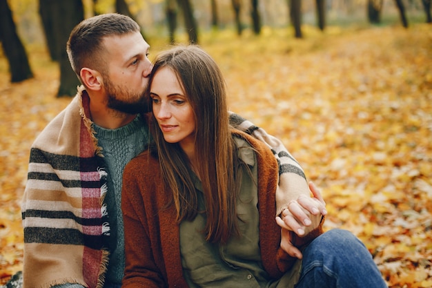 Hermosa pareja pasa tiempo en un parque de otoño