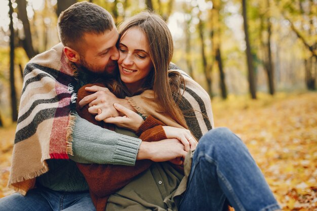 Hermosa pareja pasa tiempo en un parque de otoño