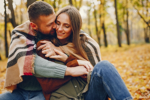 Hermosa pareja pasa tiempo en un parque de otoño