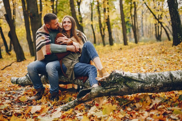 Hermosa pareja pasa tiempo en un parque de otoño