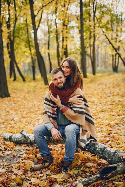 Hermosa pareja pasa tiempo en un parque de otoño