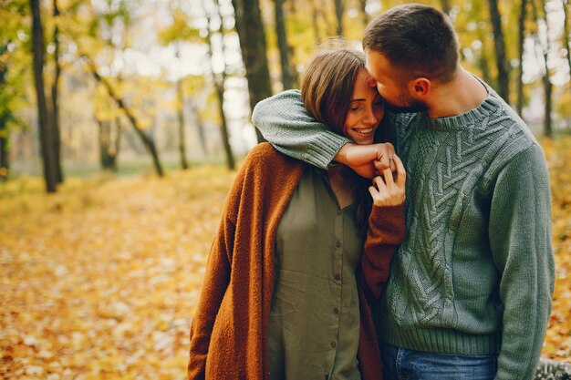 Hermosa pareja pasa tiempo en un parque de otoño