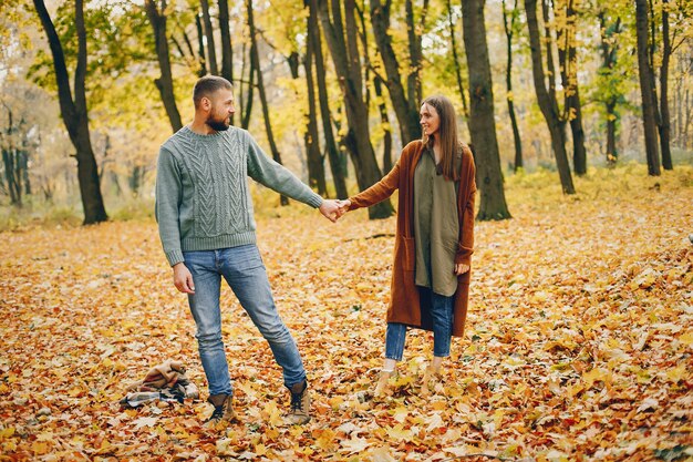 Hermosa pareja pasa tiempo en un parque de otoño