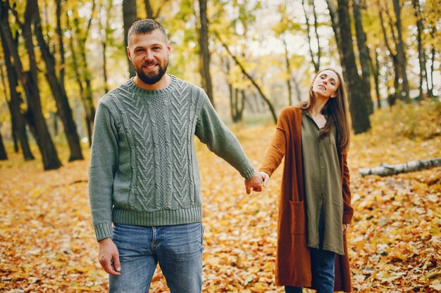 Hermosa pareja pasa tiempo en un parque de otoño