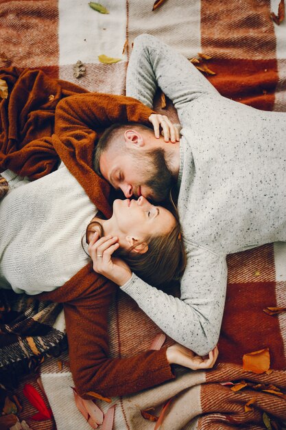 Hermosa pareja pasa tiempo en un parque de otoño