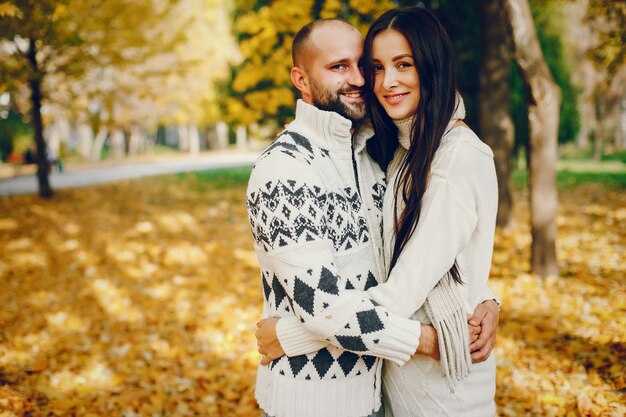 Hermosa pareja pasa tiempo en un parque de otoño