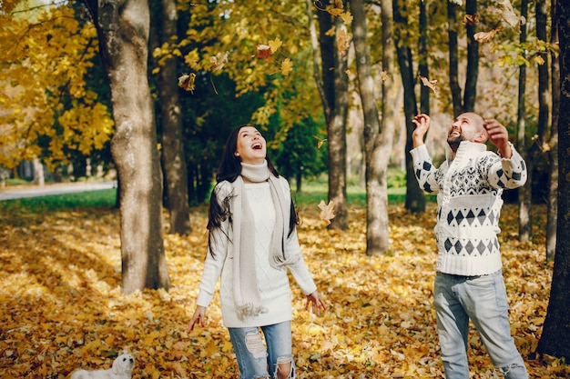 Hermosa pareja pasa tiempo en un parque de otoño