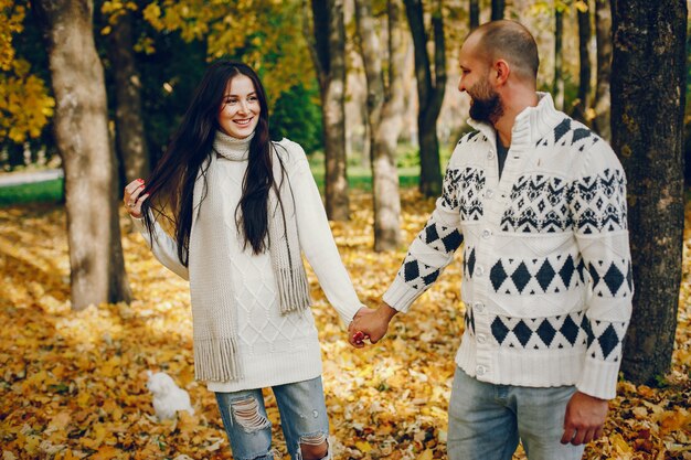 Hermosa pareja pasa tiempo en un parque de otoño