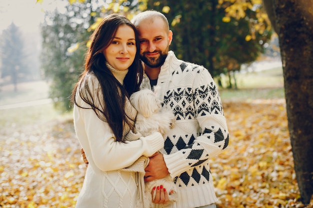 Hermosa pareja pasa tiempo en un parque de otoño