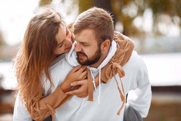 Hermosa pareja pasa tiempo en un parque de otoño