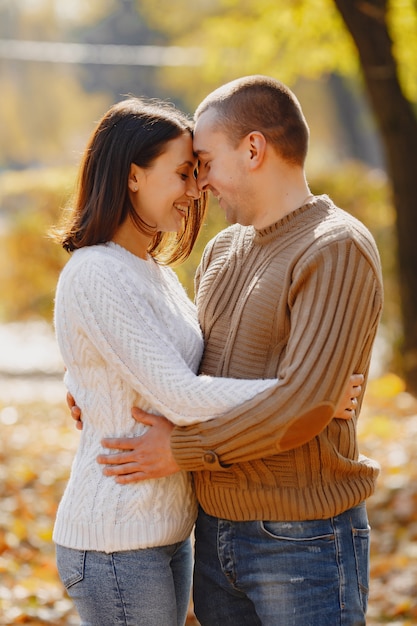 Hermosa pareja pasa tiempo en un parque de otoño