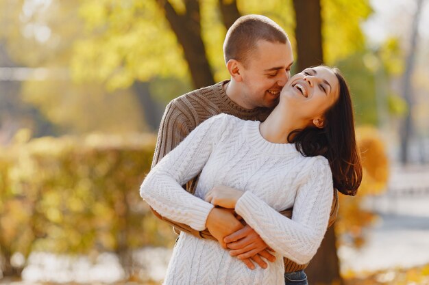 Hermosa pareja pasa tiempo en un parque de otoño