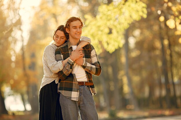 Hermosa pareja pasa tiempo en un parque de otoño