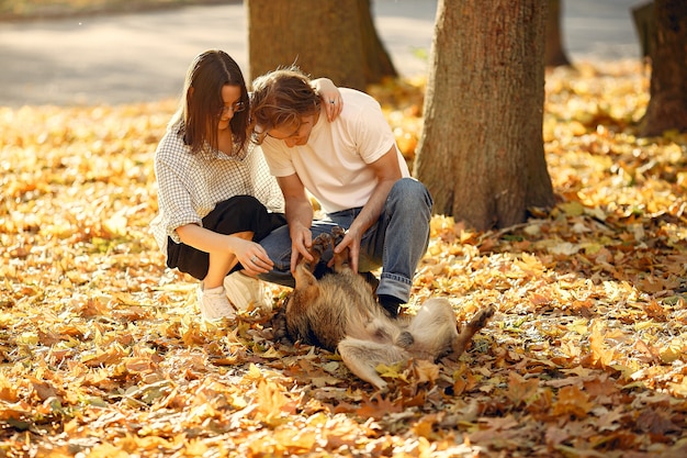 Hermosa pareja pasa tiempo en un parque de otoño