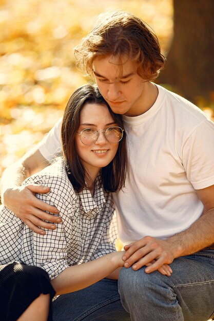 Hermosa pareja pasa tiempo en un parque de otoño