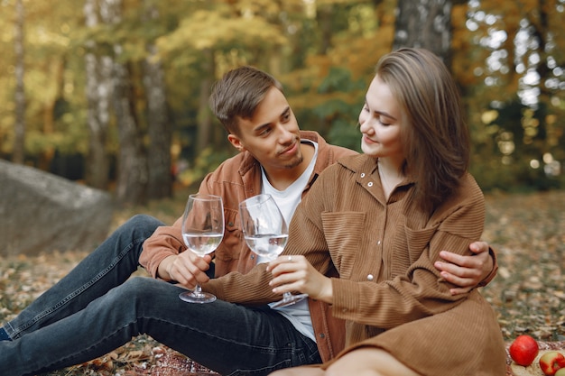 Hermosa pareja pasa tiempo en un parque de otoño