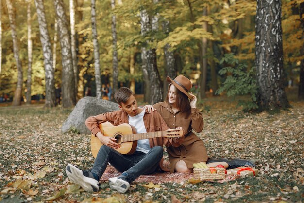 Hermosa pareja pasa tiempo en un parque de otoño