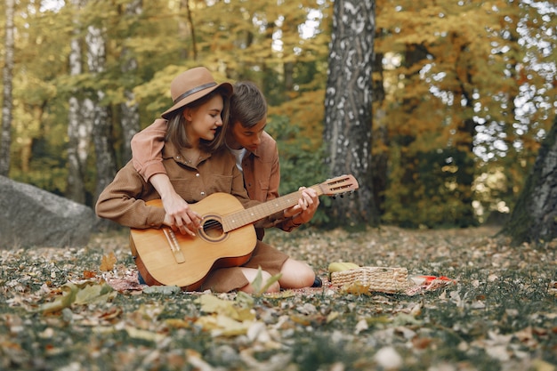 Hermosa pareja pasa tiempo en un parque de otoño