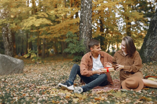 Hermosa pareja pasa tiempo en un parque de otoño