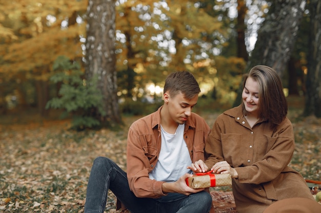 Hermosa pareja pasa tiempo en un parque de otoño