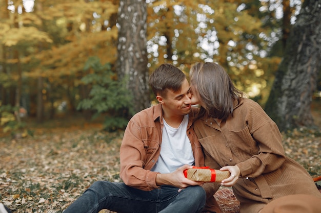 Hermosa pareja pasa tiempo en un parque de otoño