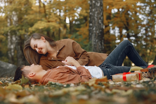 Hermosa pareja pasa tiempo en un parque de otoño