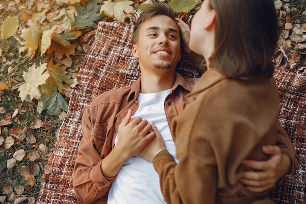 Hermosa pareja pasa tiempo en un parque de otoño