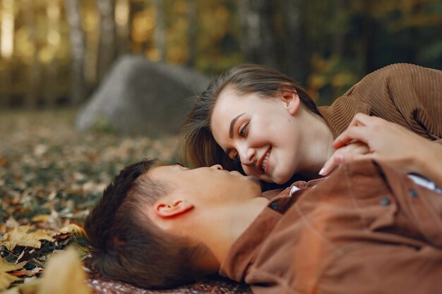 Hermosa pareja pasa tiempo en un parque de otoño