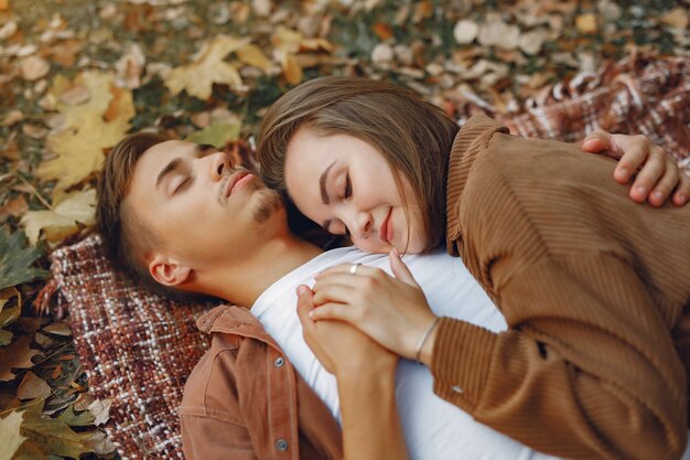 Hermosa pareja pasa tiempo en un parque de otoño