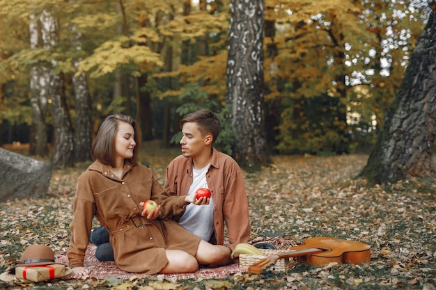 Hermosa pareja pasa tiempo en un parque de otoño