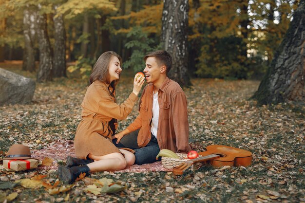 Hermosa pareja pasa tiempo en un parque de otoño