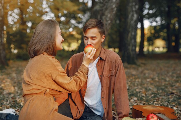 Hermosa pareja pasa tiempo en un parque de otoño