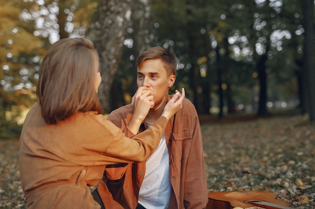 Hermosa pareja pasa tiempo en un parque de otoño