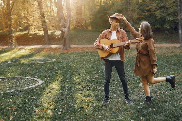 Hermosa pareja pasa tiempo en un parque de otoño