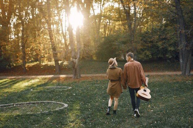 Hermosa pareja pasa tiempo en un parque de otoño