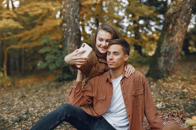 Hermosa pareja pasa tiempo en un parque de otoño