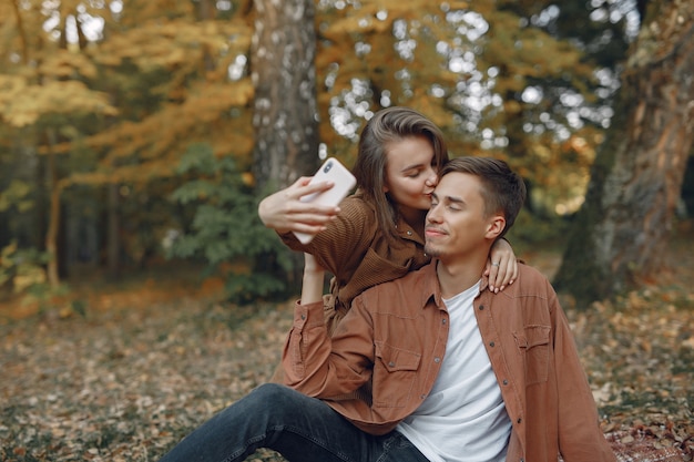 Hermosa pareja pasa tiempo en un parque de otoño