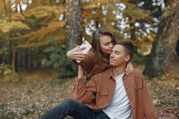 Hermosa pareja pasa tiempo en un parque de otoño