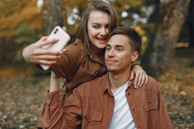 Hermosa pareja pasa tiempo en un parque de otoño