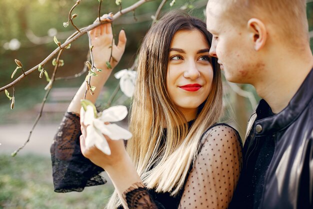 Hermosa pareja pasa tiempo en un parque de primavera