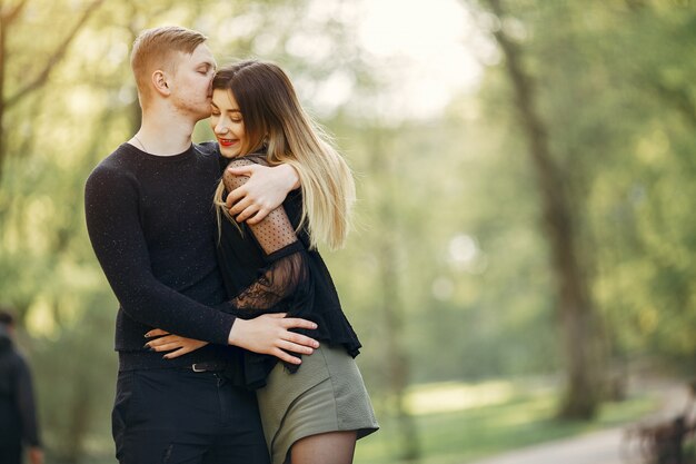 Hermosa pareja pasa tiempo en un parque de primavera