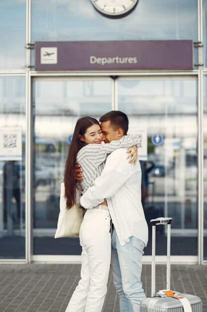 Hermosa pareja de pie cerca del aeropuerto