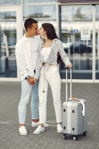 Hermosa pareja de pie cerca del aeropuerto