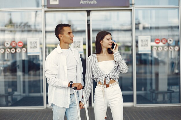 Hermosa pareja de pie cerca del aeropuerto